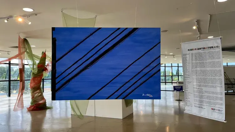 Exposição com uma pintura de fundo azul e linhas pretas, de Daniel da Hora, em exibição na Estação Cabo Branco.
