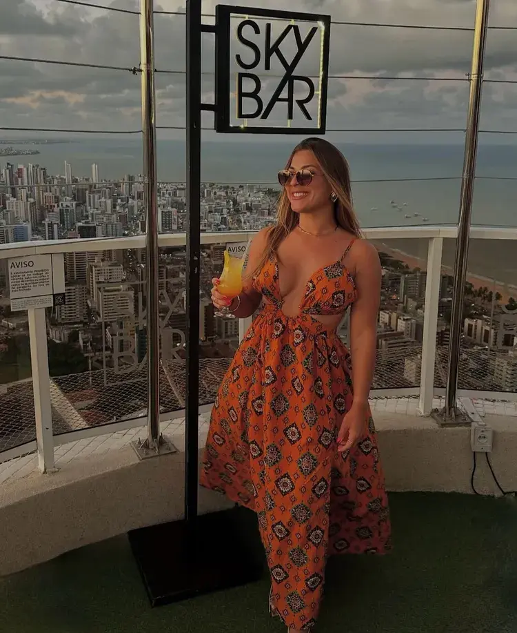 Cesta com petiscos fritos e um molho em um fundo de luz natural, representando a experiência gastronômica no rooftop.