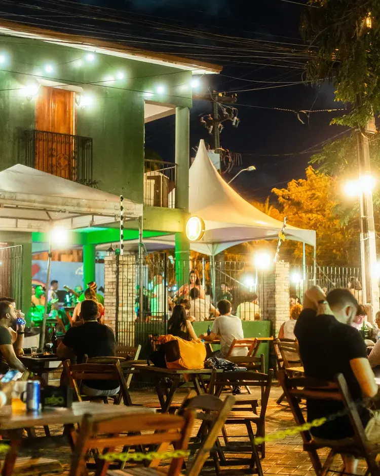 Imagem do Recanto Jampa com pessoas se divertindo em um ambiente festivo. O evento Baile da Motinha 2.0 está programado para começar às 21h, com DJs Vex e Borgato.