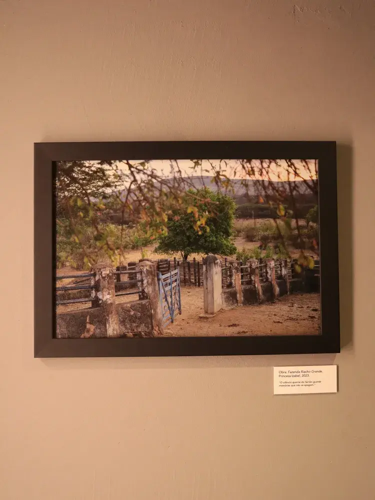 Fotografia intitulada Fazenda Riacho Grande, Princesa Isabel, 2023, parte da exposição Entre o Sertão e o Japão, com paisagem rural e cerca de pedra e madeira ao pôr do sol.