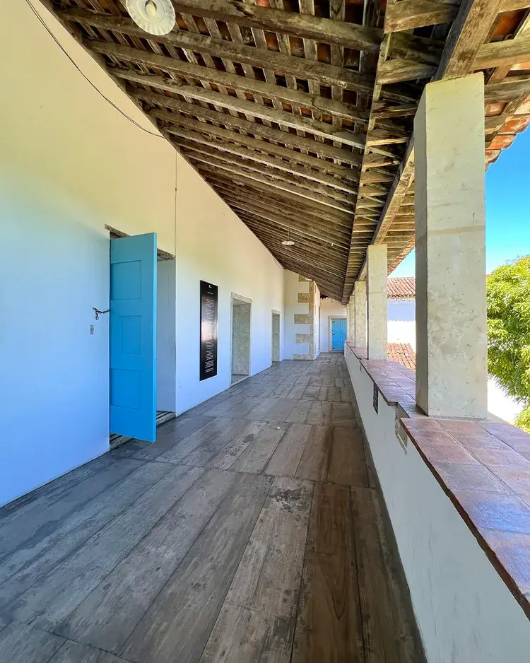 Corredor do Centro Cultural São Francisco com portas azuis abertas, mostrando ambiente histórico e arquitetura colonial, texto na legenda menciona horários especiais de visitação em 31 de dezembro e retomada em 2 de janeiro.