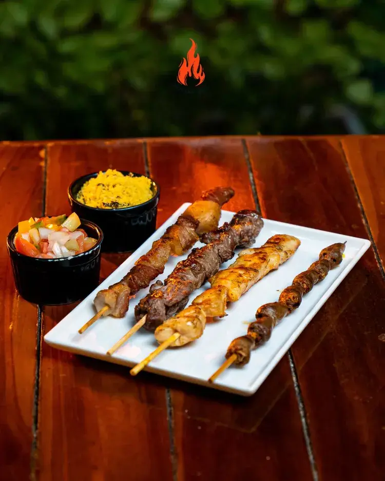 Espetinhos variados e pratos com acompanhamentos, ideal para a Quinta de Espetos na Parrilha Grill.