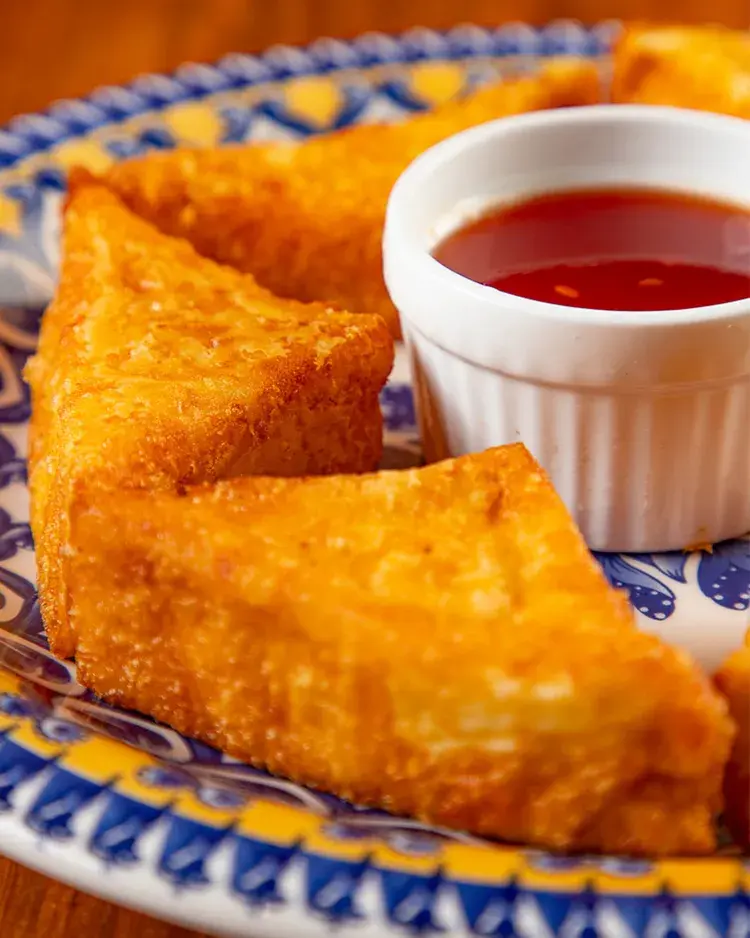 Prato de queijinho empanado ao lado de um molho de pimenta, servido no Restaurante Parraxaxá.